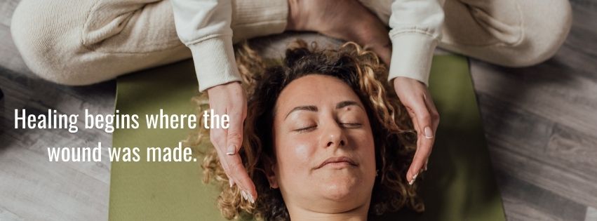 A person lying down with closed eyes during a relaxation or healing session, symbolizing emotional healing and inner peace.